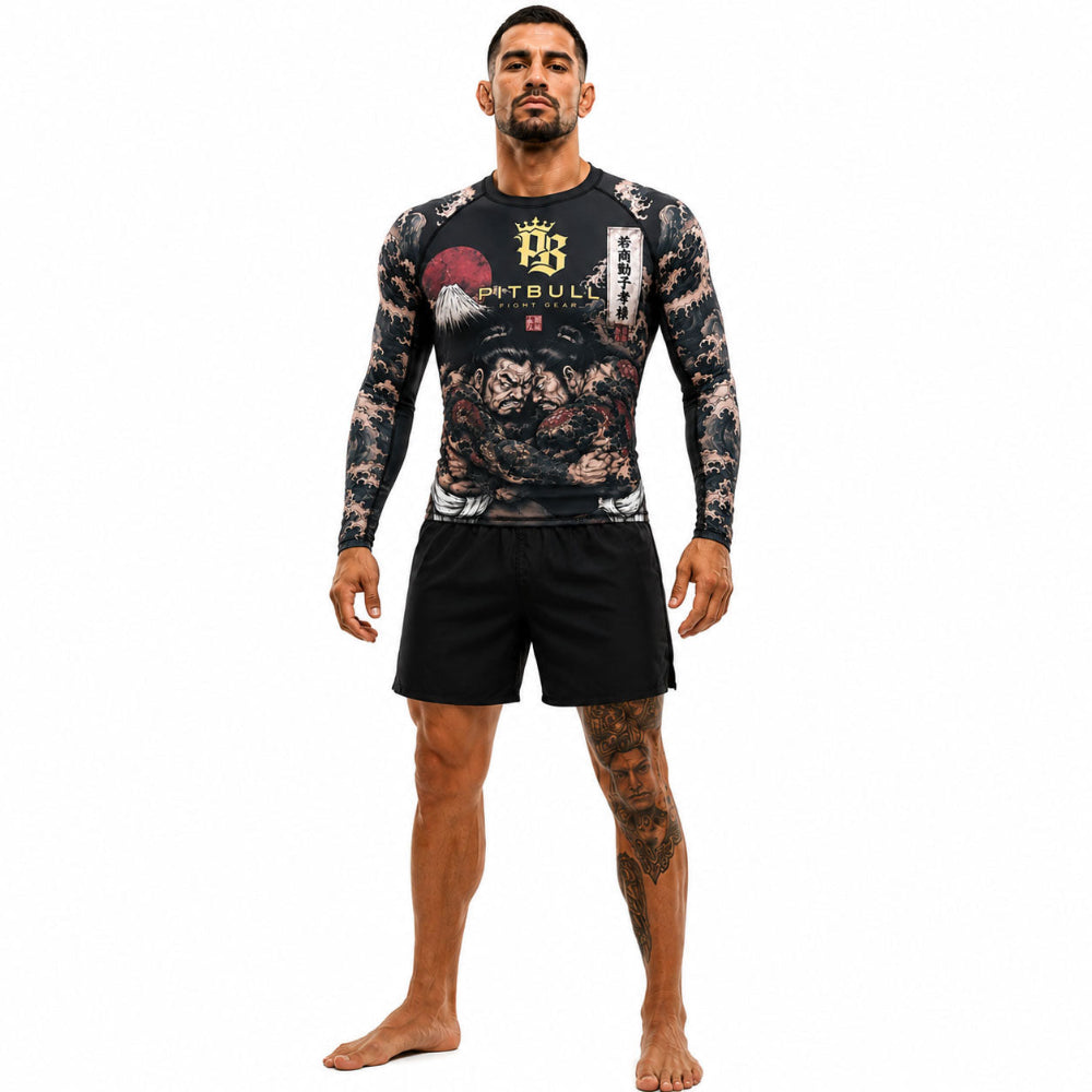 Man wearing a patterned long-sleeve shirt and black shorts with a visible brand logo on a white background