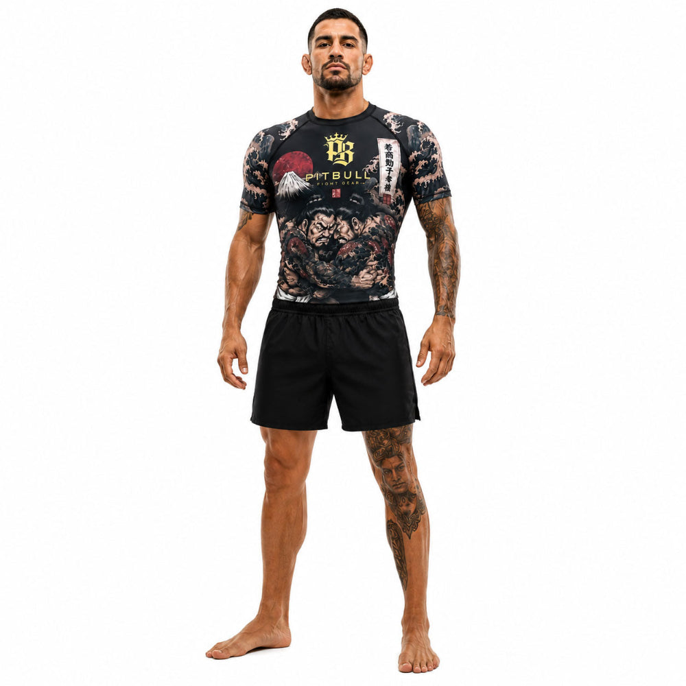 Man wearing a black athletic outfit with a tattoo design on a white background